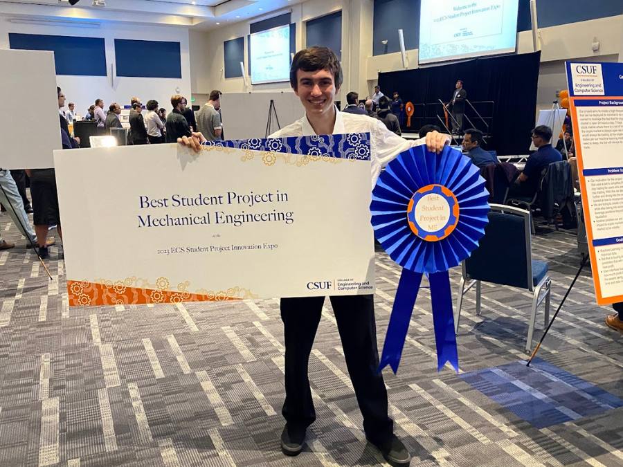 Nicholas Thomas holding a Best Student Project in Mechanical Engineering award